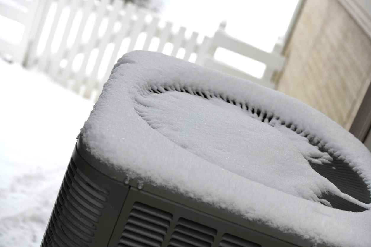 Fresh snow on top of a heat pump.