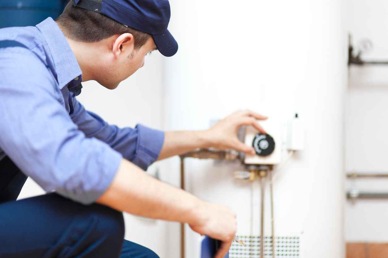 Smiling technician repairing an hot-water heater